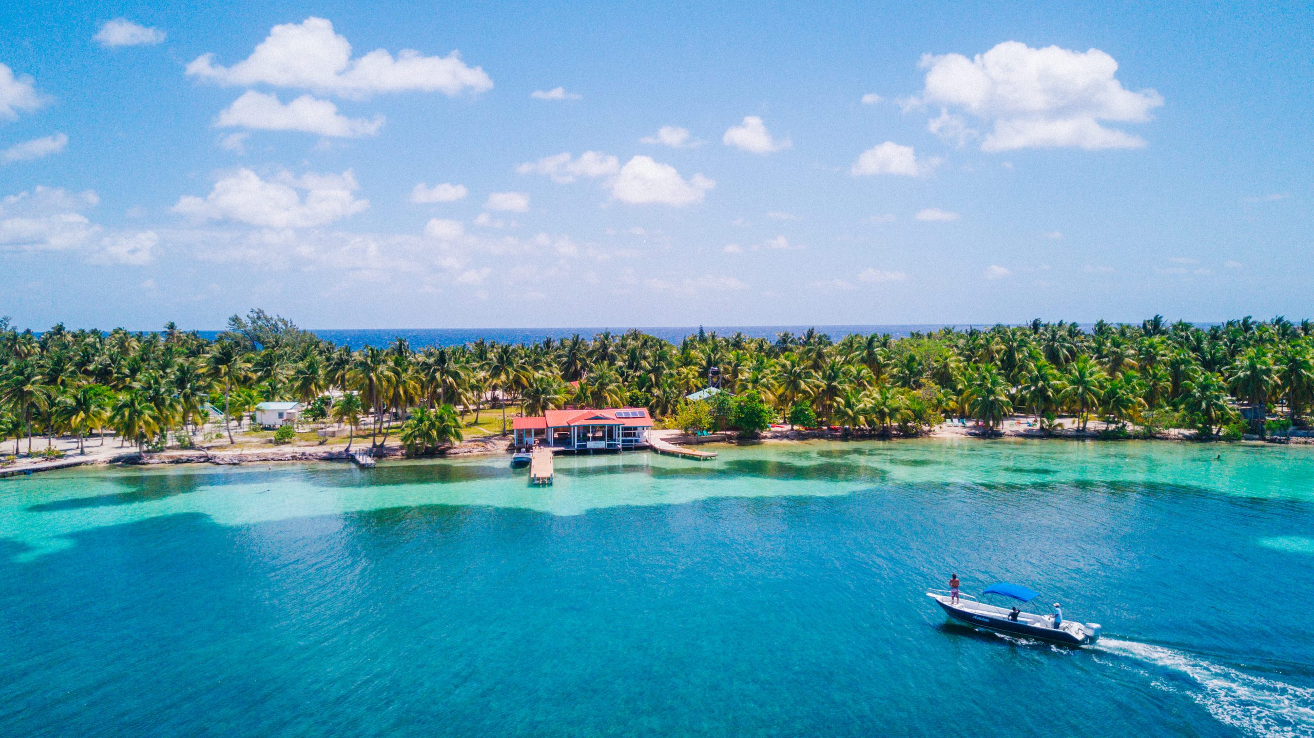 Aerial view of a clear turquoise Caribbean caye with clean white sand and open water